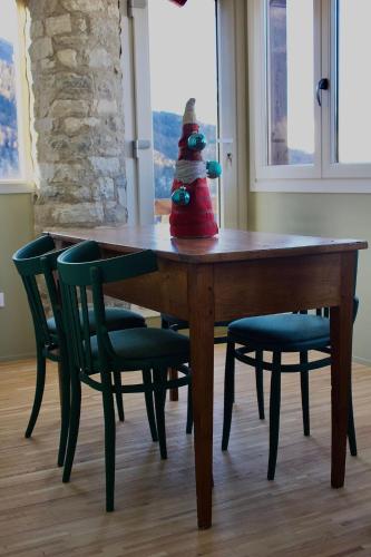 a santa claus toy sitting on a table with chairs at Ca' De Sass in Pila