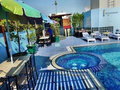 a swimming pool with a table and an umbrella at Knight Armour Hotel in Dubai