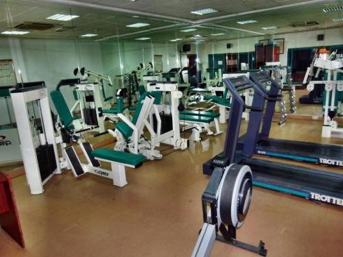 a gym with a lot of treadmills and machines at Knight Armour Hotel in Dubai
