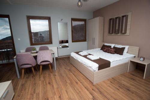 a bedroom with a bed and a table and chairs at Villa La Munte in Kruševo