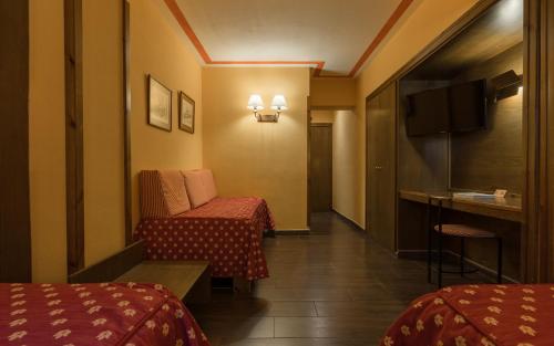 a hotel room with two beds and a table at Hotel Aran La Abuela in Vielha