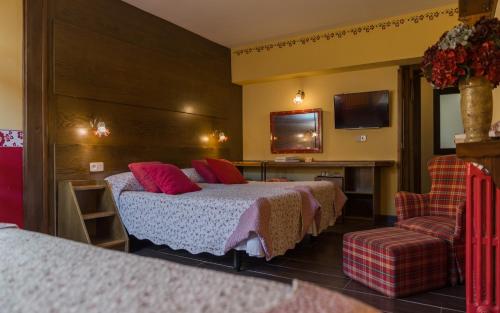 a hotel room with a bed and a chair at Hotel Aran La Abuela in Vielha