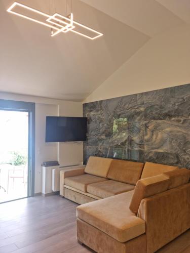 a living room with a couch and a tv at Giannis Village Resort in Astakós