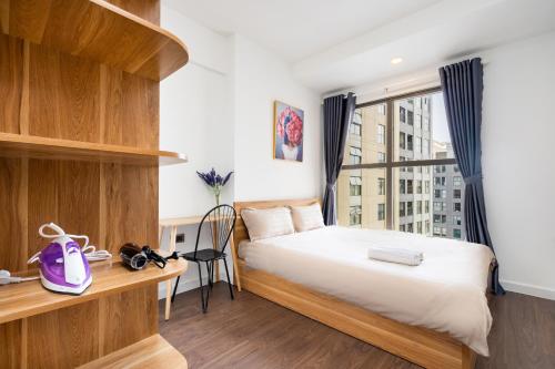 um quarto com uma cama, uma secretária e uma janela em 1st district - best price/two bedrooms apartments - the SOHO em Ho Chi Minh