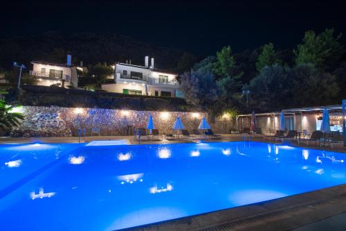 a large blue swimming pool at night at Giannis Village Resort in Astakós