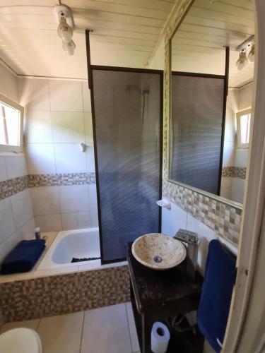een badkamer met een bad, een wastafel en een spiegel bij Acutí Departamento in Puerto Iguazú