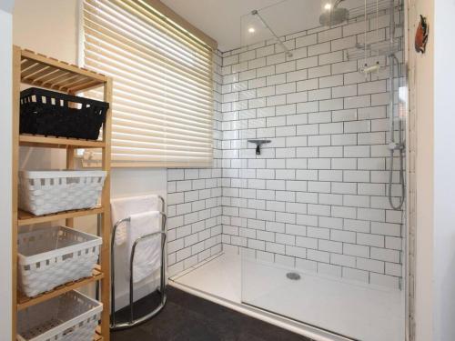 a bathroom with a shower and a white tiled wall at Large Family Home Private Garden Beach 2 mins Walk in South Hayling