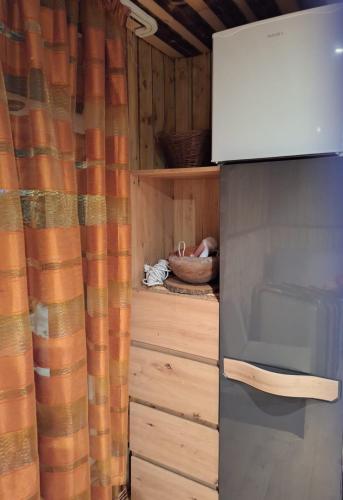 a kitchen with a wooden cabinet and a microwave at PIE OPĪŠA in Cēsis