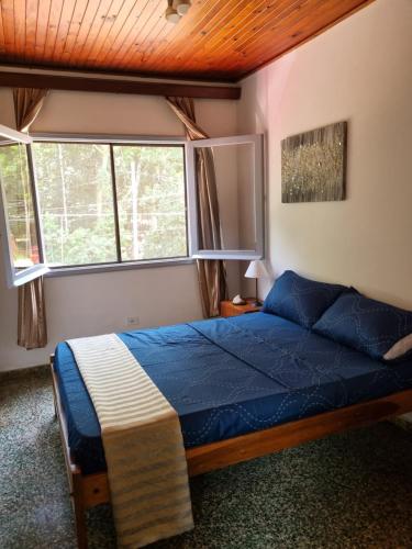 een slaapkamer met een bed en twee ramen bij Acutí Departamento in Puerto Iguazú