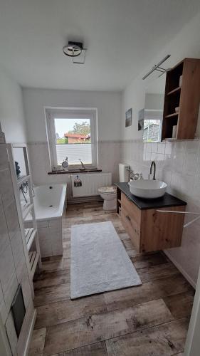 a bathroom with a sink and a tub and a toilet at Ferienwohnung Feldblick in Upahl