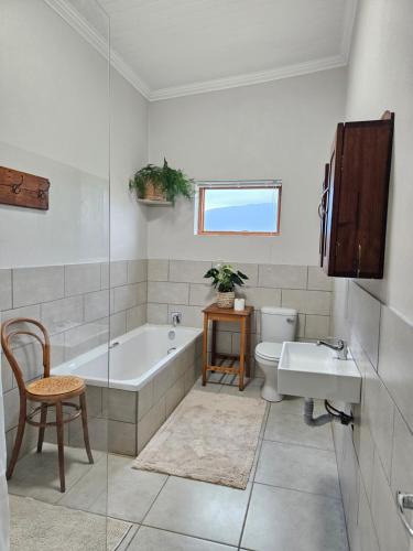 a bathroom with a tub and a sink and a toilet at Lowergroen Guestfarm, Working Farm in Swellendam