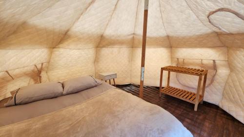 duży namiot z łóżkiem i stołem w obiekcie Glamping Río Serrano - Caja Los Andes w mieście Puerto Natales