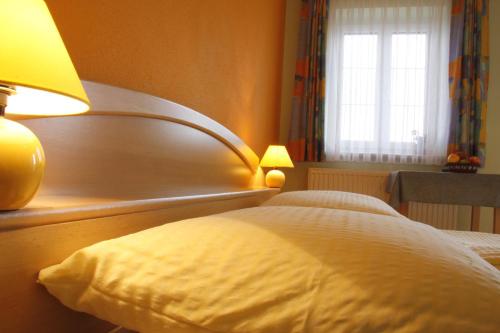 ein Schlafzimmer mit einem Bett mit einer Lampe und einem Fenster in der Unterkunft Spezialitätenhof Familie Eichmann in Neuhaus am Klausenbach