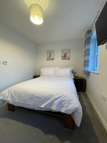 1 dormitorio con cama blanca y ventana en Tootle Drive, en Longridge