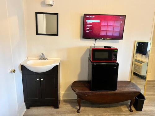 a microwave sitting on top of a table next to a sink at Spruce Pine Inn in Spruce Pine