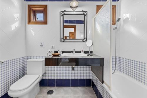 a bathroom with a sink and a toilet and a mirror at Villa Bezanilla - VipVipVillas in Playa Blanca
