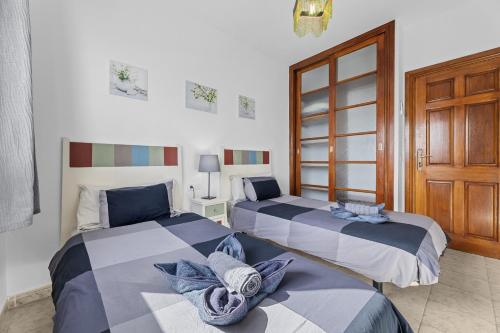 a bedroom with two beds and a wooden door at Villa Bezanilla - VipVipVillas in Playa Blanca