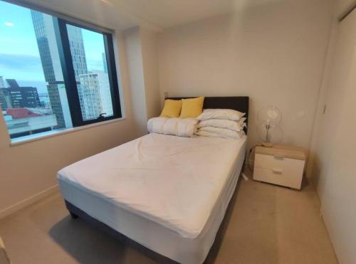 a bedroom with a large bed with a window at Sky View in Auckland