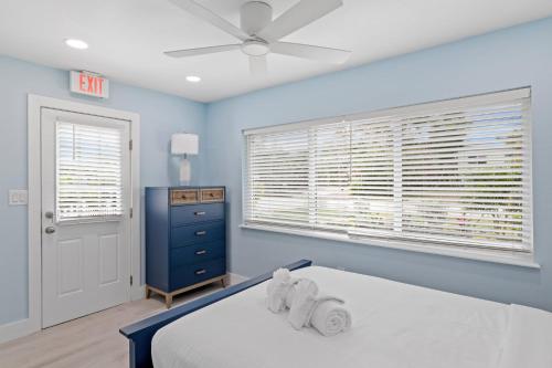 um quarto azul com uma cama e uma ventoinha de tecto em Palm Retreat - Large Cottage on Sanibel Island with Bikes em Sanibel