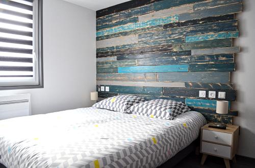 a bedroom with a bed and a wooden wall at Eco-Appart'hôtel Rouen -- BDE in Rouen