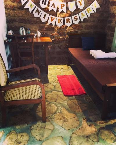 a room with a bed and a chair and a table at Sky View Cabin Unawatuna in Unawatuna