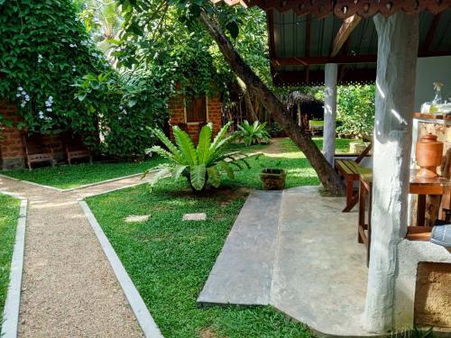 a garden with a patio and a tree at Sky View Cabin Unawatuna in Unawatuna