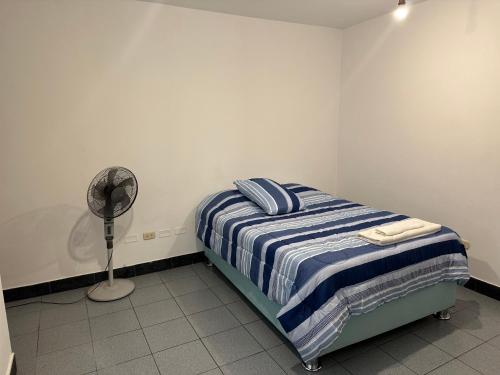 a bedroom with a bed and a fan at Habitacion doble huaca Miraflores in Lima