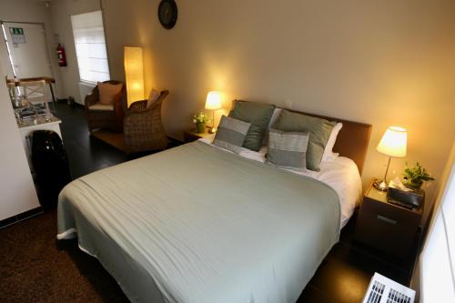 a bedroom with a large bed and a chair at Vakantiewoning Casa Maran in een groene omgeving te Heusden-Zolder in Heusden - Zolder