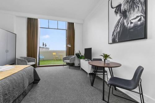 een hotelkamer met een bed en een tafel en stoelen bij Happy Days in Auckland