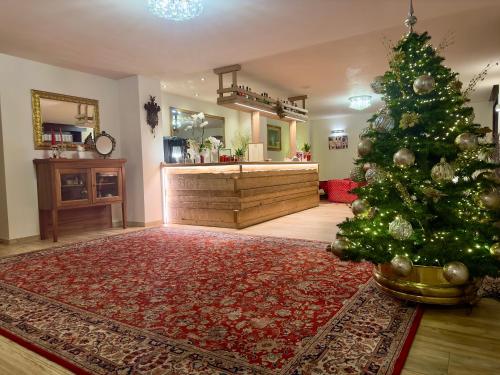 a christmas tree in the middle of a living room at Hotel Zeni in Madonna di Campiglio