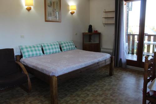 a bedroom with a bed and a chair and a window at LA Source Blanche in Saint-Jean