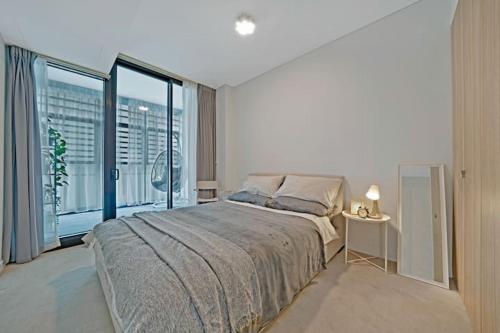 ein Schlafzimmer mit einem großen Bett und einem großen Fenster in der Unterkunft Stylish 1BR Entire CBD Apt 5 Minutes Train Station in Sydney