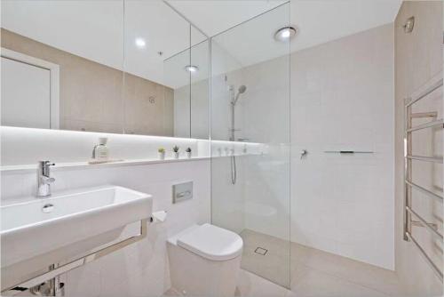 La salle de bains est pourvue de toilettes, d'un lavabo et d'une douche. dans l'établissement Stylish 1BR Entire CBD Apt 5 Minutes Train Station, à Sydney