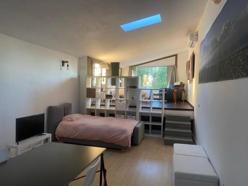 1 dormitorio con 1 cama y 1 habitación con ventana en LOFT CAL XURIGUER, en Font-Rubí