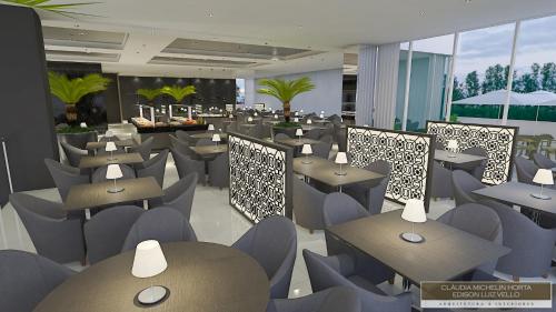 a restaurant with tables and chairs in a building at White Plaza Hotel in Curitiba