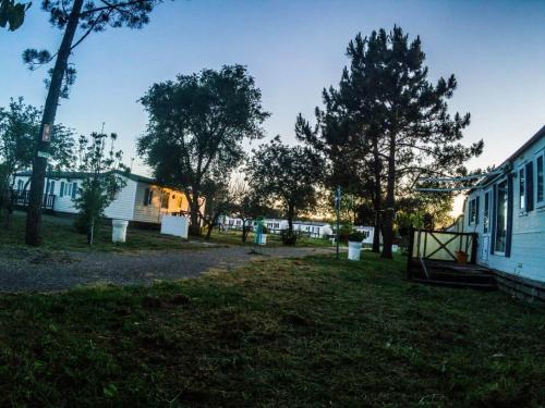 a group of buildings in a yard with trees at Bungalows Land'shause in Pataias