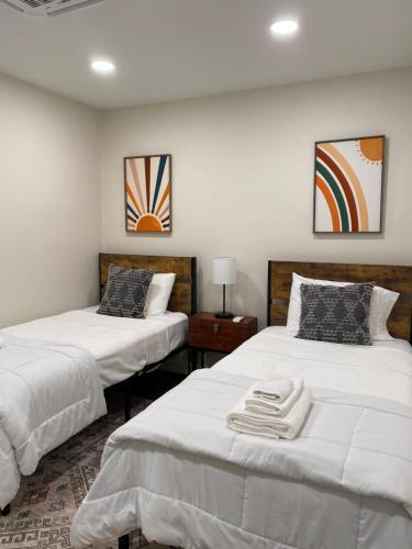 duas camas com lençóis brancos num quarto em Downtown Brevard, Franklin Park & College - Updated 3bd 2ba home, Pets ok em Brevard