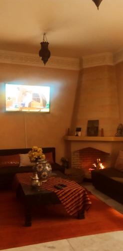 a living room with a couch and a fireplace at maison d'hôtes Le petit jardin Marrakech in Marrakech