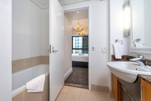 ein Badezimmer mit einer Badewanne, einem Waschbecken und einer Badewanne in der Unterkunft Viaduct Stunner in Auckland