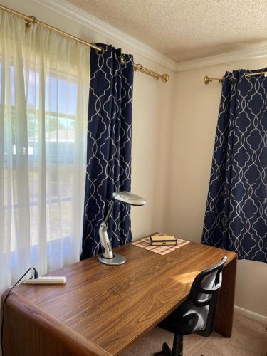 a desk with a lamp and a chair in front of a window at Executive Room in North Fort Myers