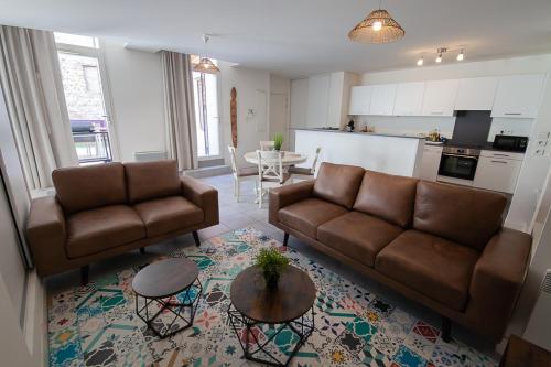 un salon avec deux canapés bruns et une cuisine dans l'établissement CAN MAYRA, à Perpignan