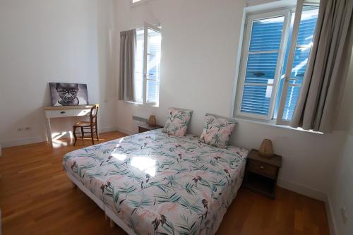 une chambre avec un lit, un bureau et des fenêtres dans l'établissement CAN MAYRA, à Perpignan