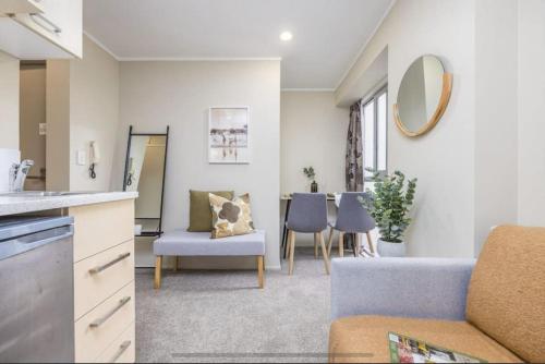 uma sala de estar com um sofá e uma mesa em Pocket Rocket One Bed Apartment em Auckland