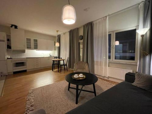 uma sala de estar com um sofá e uma mesa em Mysig lägenhet i City em Norrköping