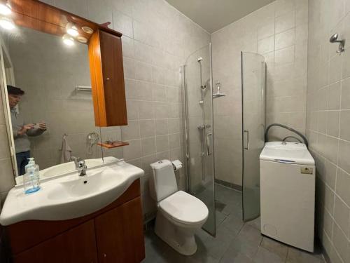 a bathroom with a sink and a toilet and a mirror at Mysig lägenhet i City in Norrköping