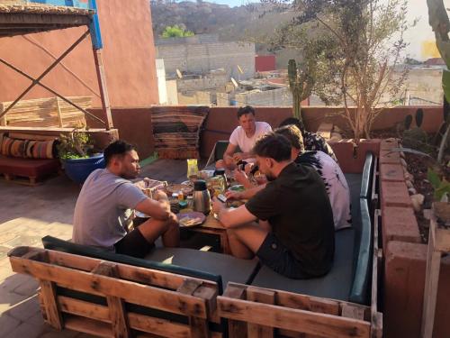 a group of people sitting around a table eating food at Chiwash Place Taghazout in Taghazout
