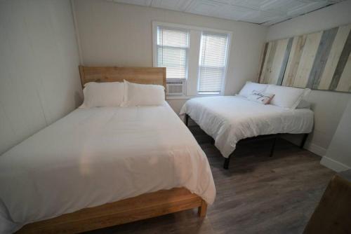 een slaapkamer met 2 bedden en een raam bij The Historic Oneida Lake House - Condo 3 in Blossvale