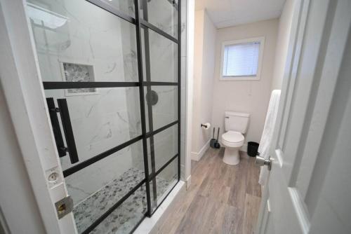 a bathroom with a toilet and a glass shower door at The Historic Oneida Lake House - Condo 3 in Blossvale