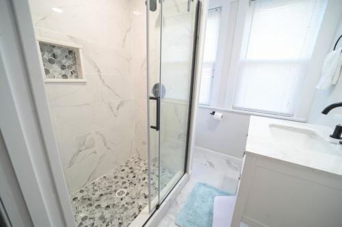 La salle de bains est pourvue d'une douche avec une porte en verre. dans l'établissement The Historic Oneida Lake House - Condo 4, à Blossvale