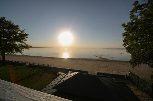 a view of a beach with the sun setting at Historic Oneida Lakefront 2BR 1BA Condo 4 in Blossvale